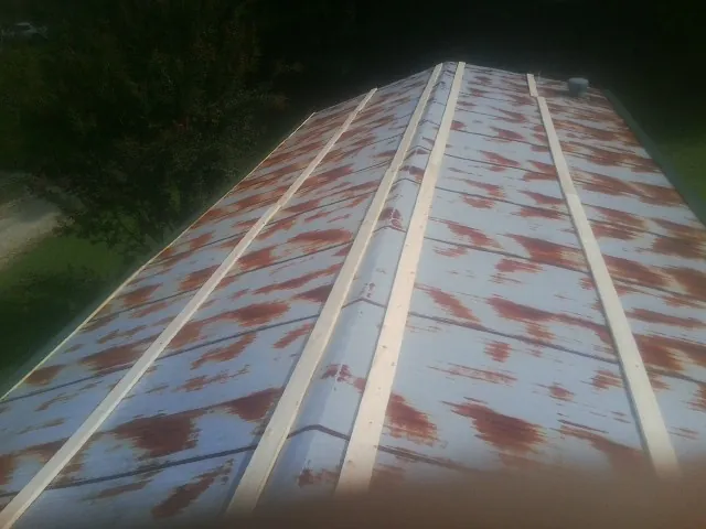Rusted metal roof panels with new wood purlins before replacement — Storm Damage Roof Repair in Epsom by Roofing Brothers